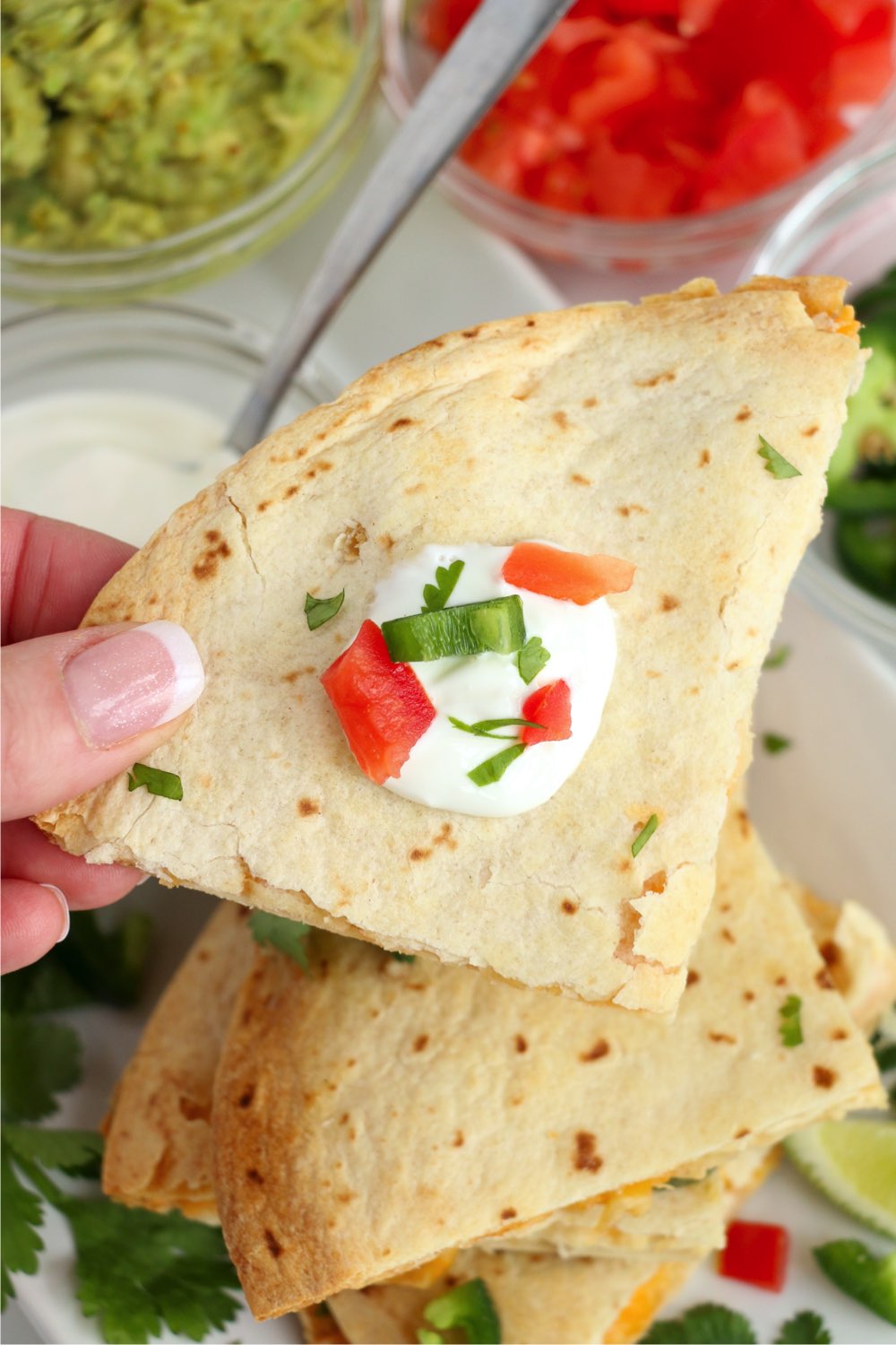holding a piece of a quesadilla