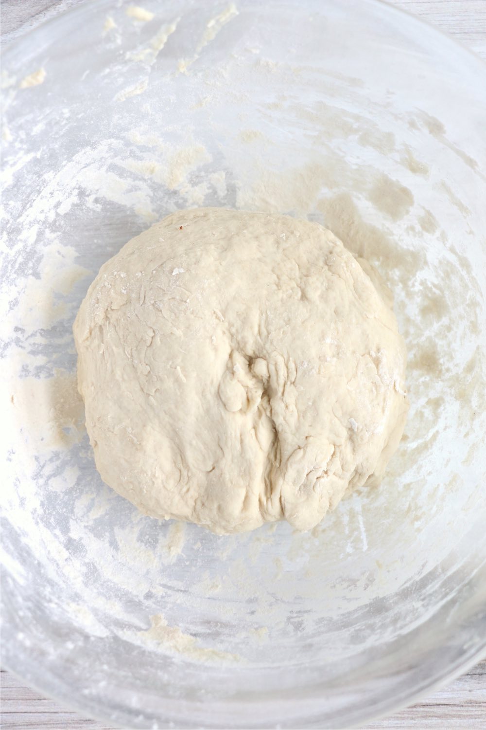 ball of pretzel dough in glass bowl 