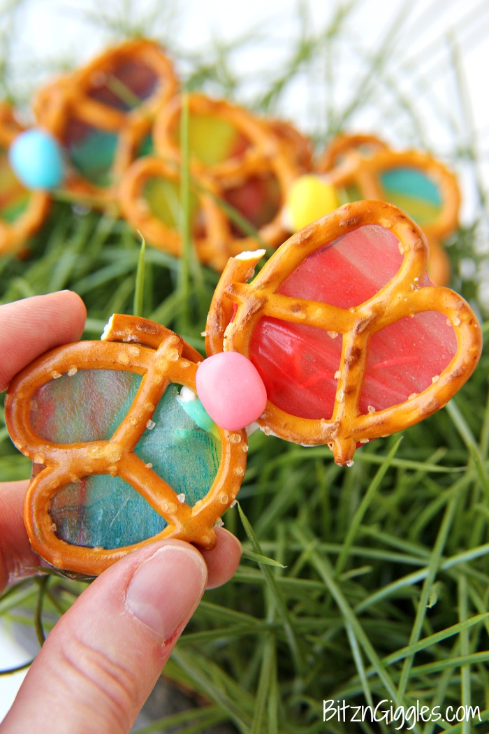 Alright, break two pieces off the third pretzel for the butterfly antennae, flip the butterfly over, dab a bit more melted candy coating on the back of the butterfly and position the antennae. Allow this to set for a few minutes.