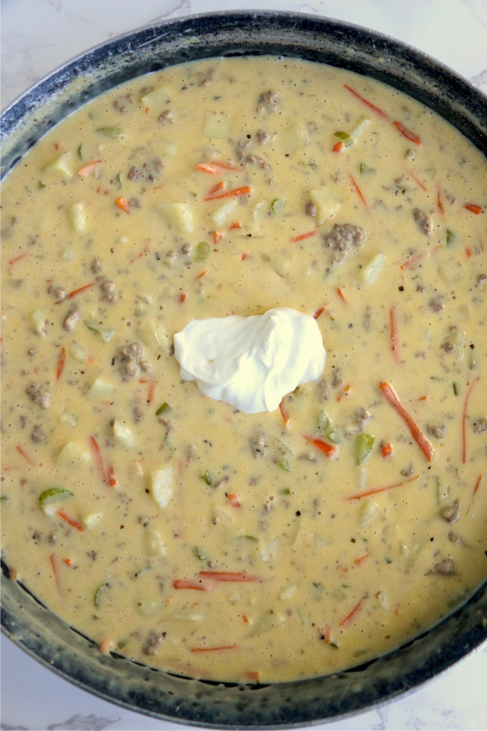 dollop of sour cream in the middle of pot of soup