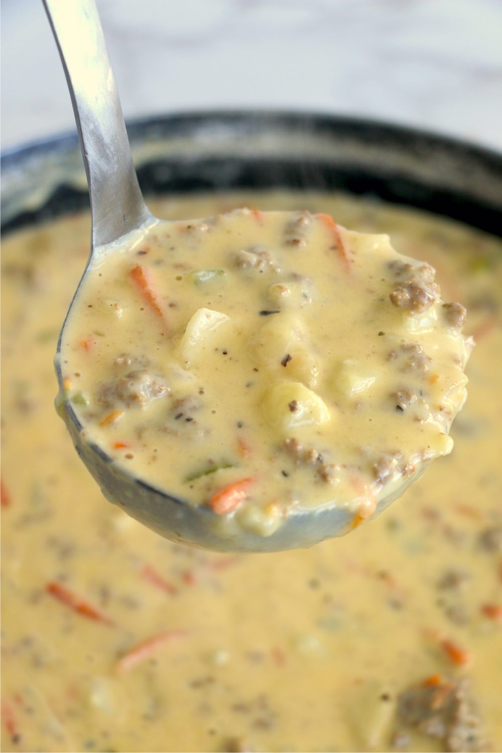 ladle filled with cheeseburger soup