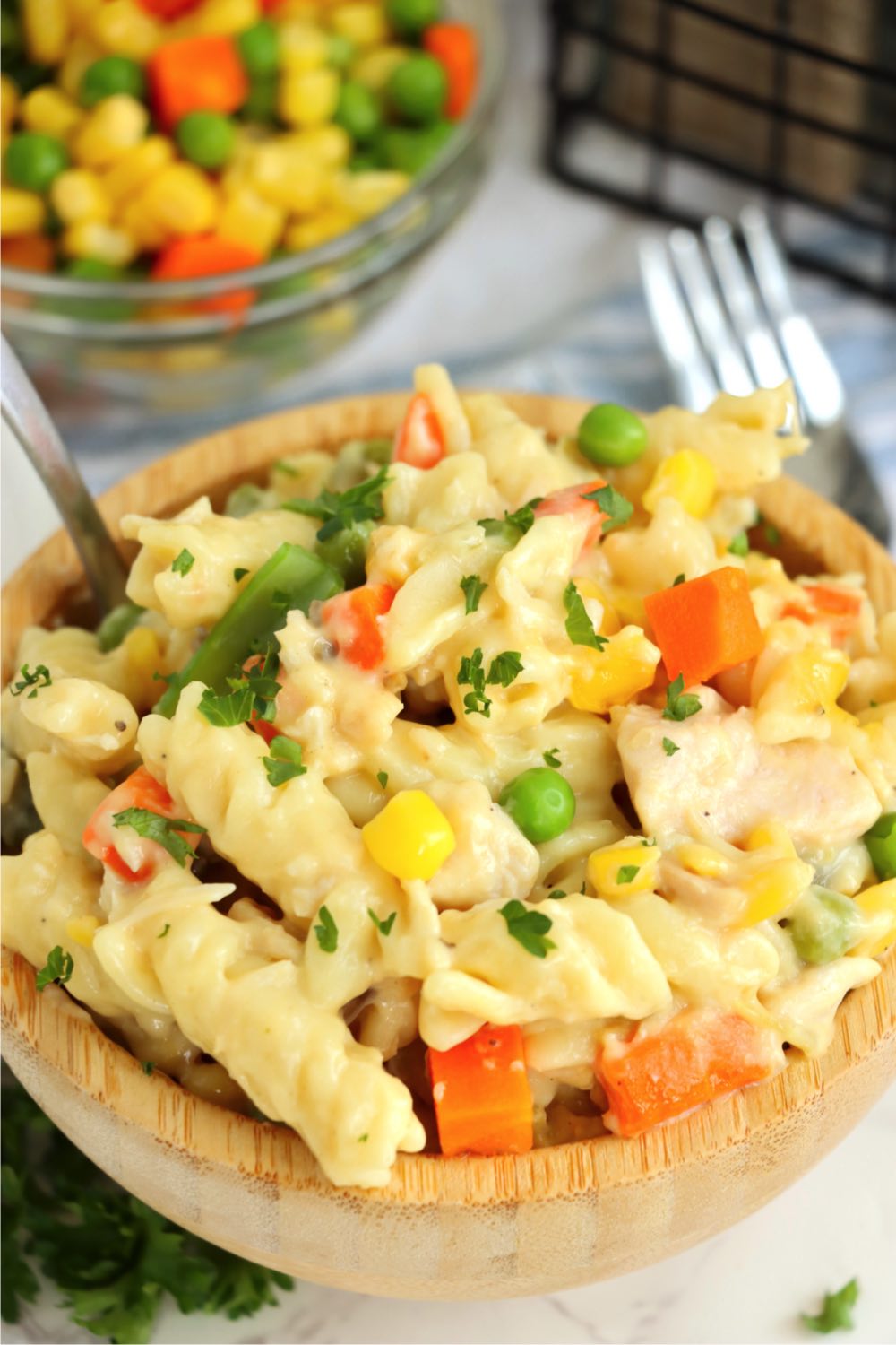 small wooden bowl filled with veggie pasta 