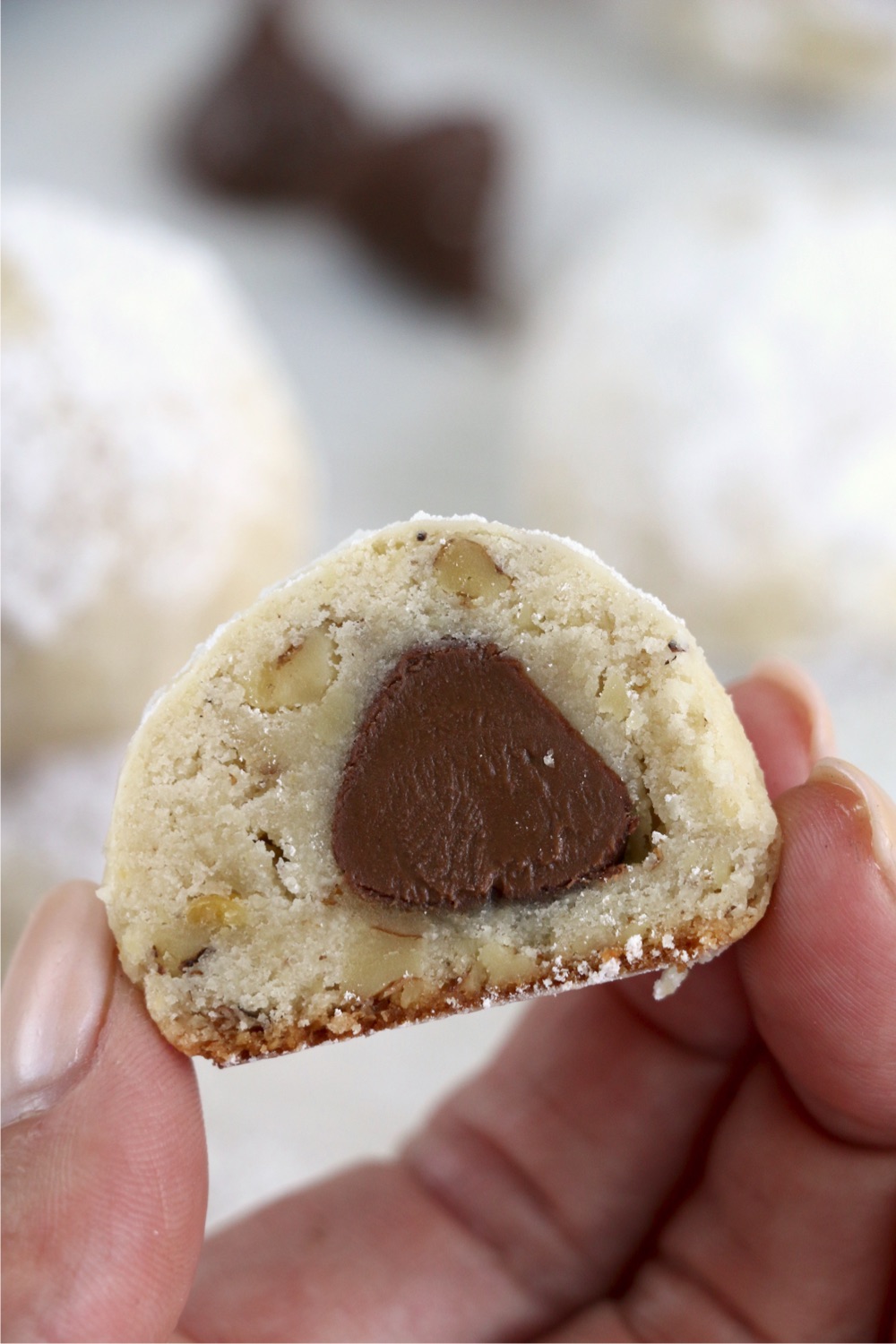 Hand showing inside of snowball kiss cookie