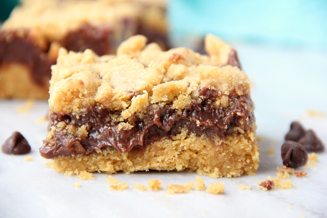 Fudge Crumble Bars - Fudge, peanut butter and coconut pecan frosting enveloped by a delicious yellow cake mix crust and crumble topping!