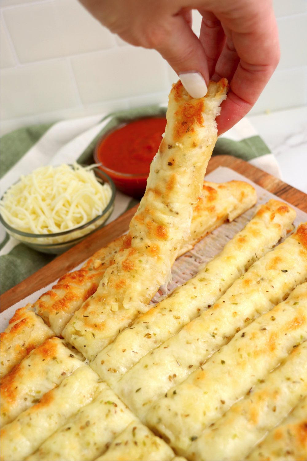 hand lifting out a breadstick to eat