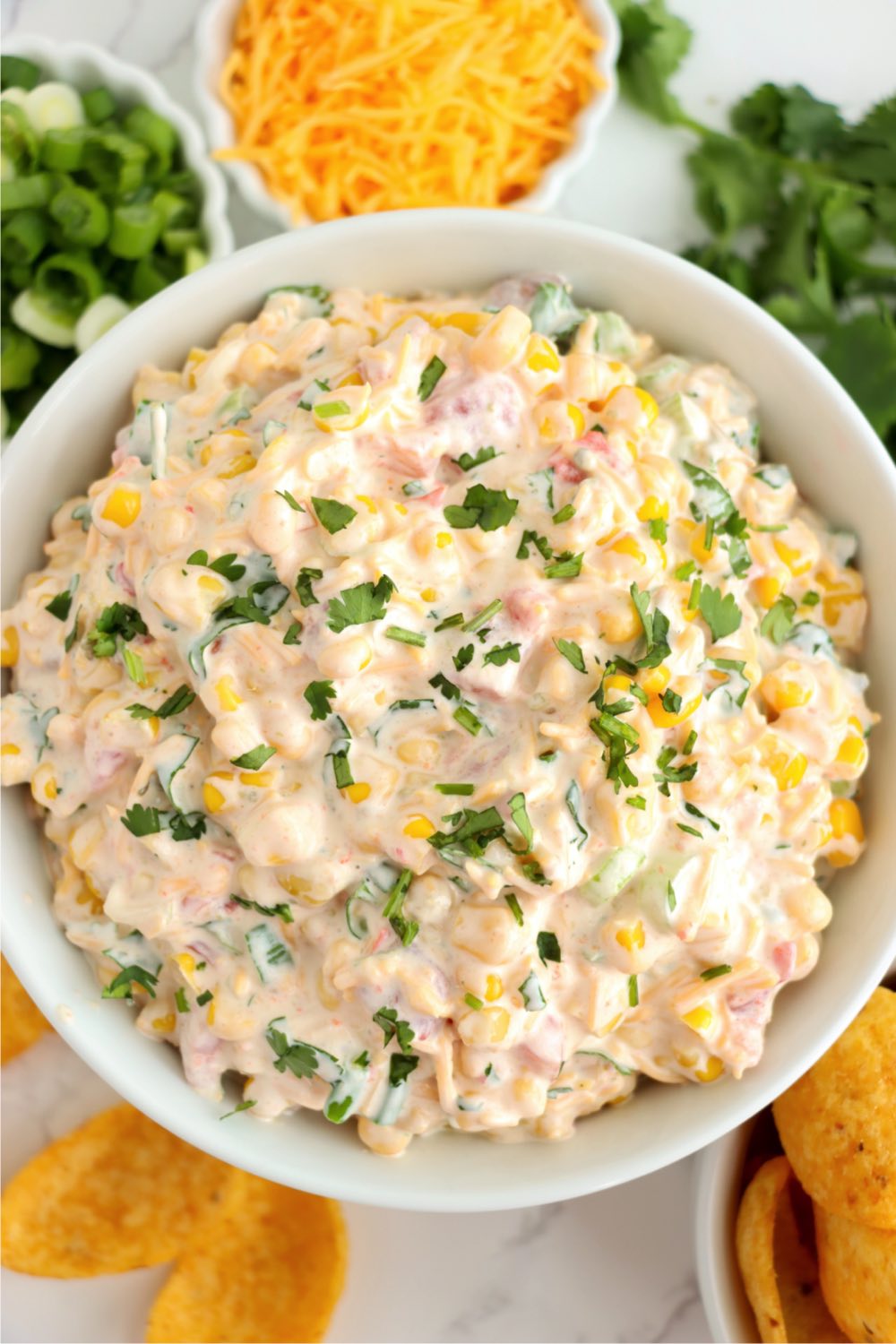 Looking down at a bowl of Mexican corn dip with cilantro