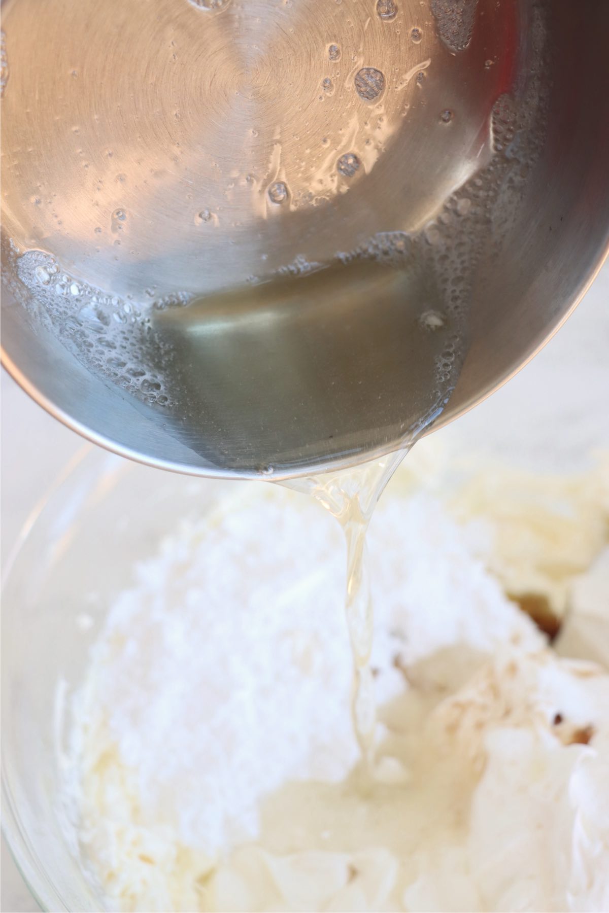 Pouring liquid gelatin into a bowl with other cheesecake ingredients