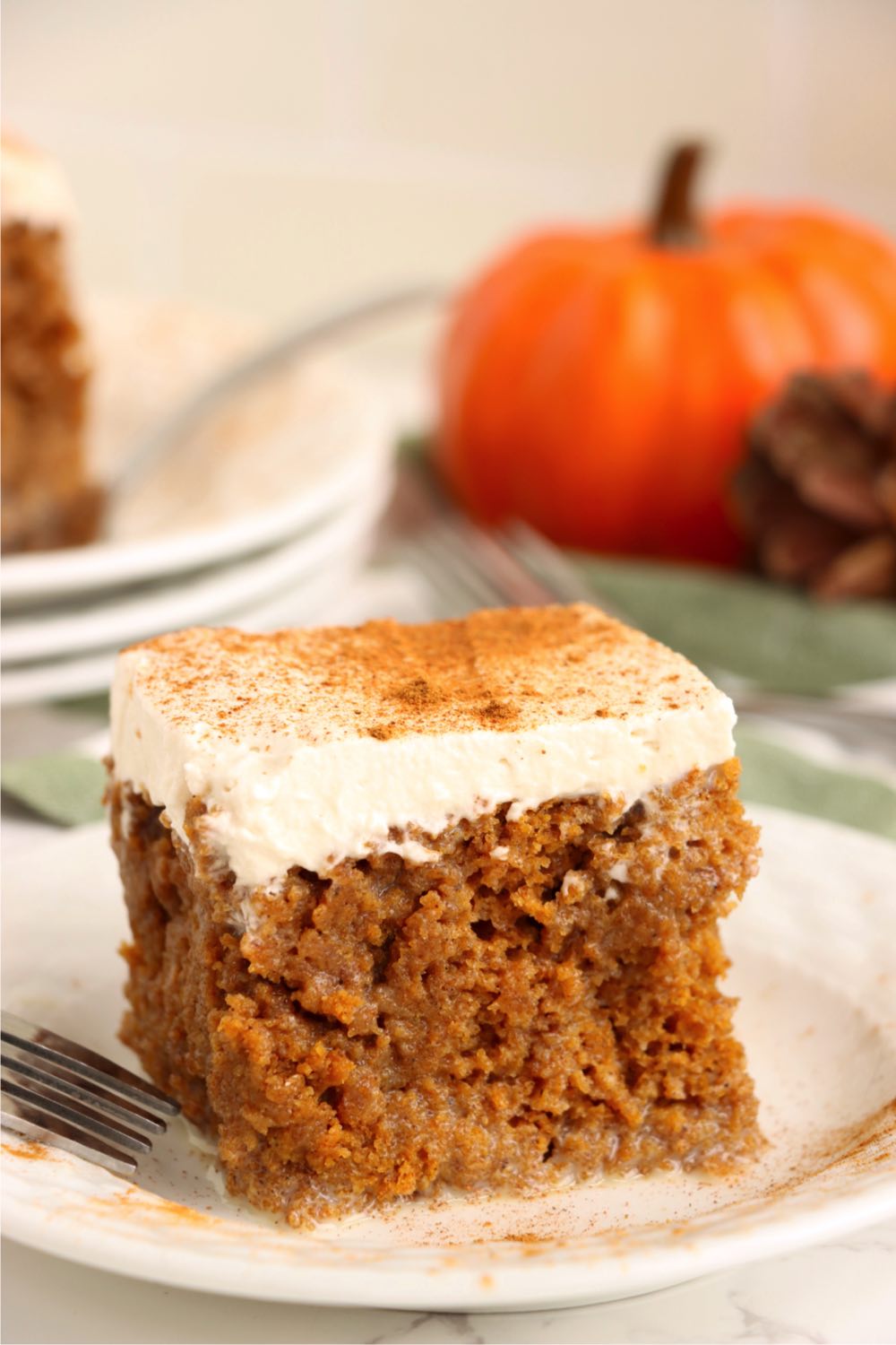 piece of pumpkin poke cake on white dessert plate