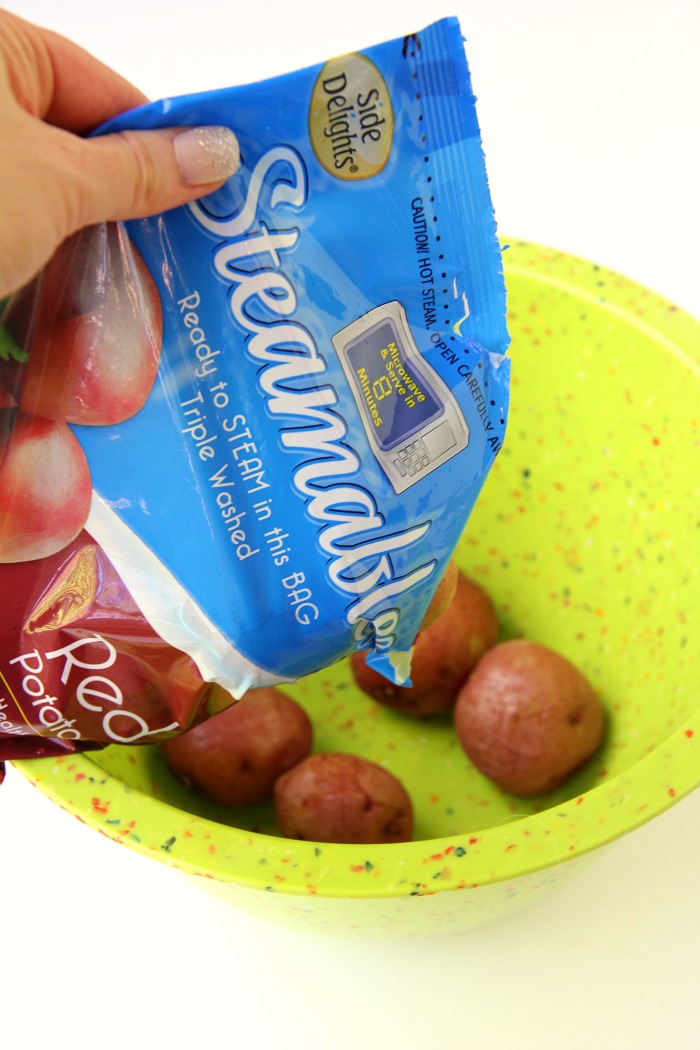 Twice Baked Potato Bowl - Baby reds are steamed, mashed, loaded with delicious toppings and then drizzled with a cheesy broccoli sauce. Tastes just like a twice baked potato but prepared in record time!