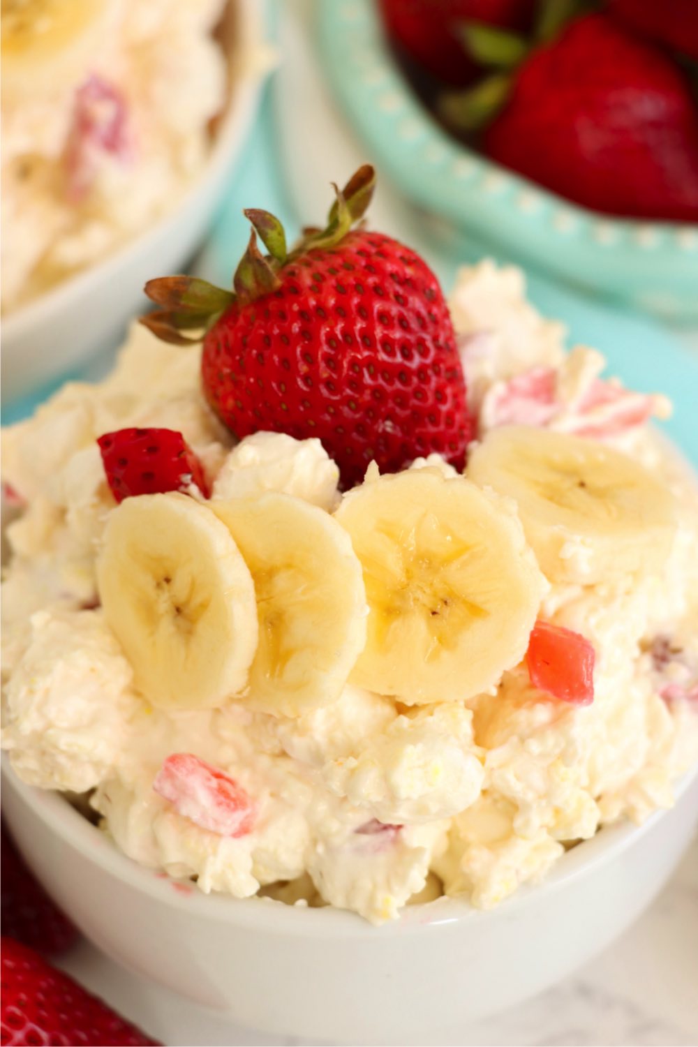 Small white bowl filled with a fruit fluffy salad.
