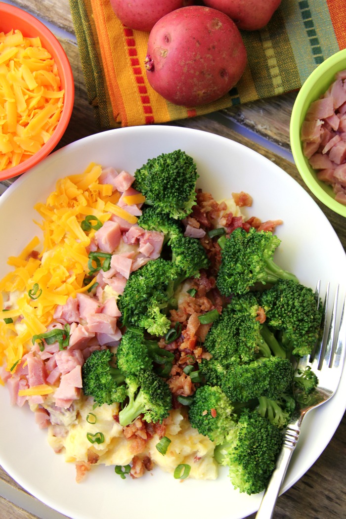 Twice Baked Potato Bowl - Baby reds are steamed, mashed, loaded with delicious toppings and then drizzled with a cheesy broccoli sauce. Tastes just like a twice baked potato but prepared in record time!