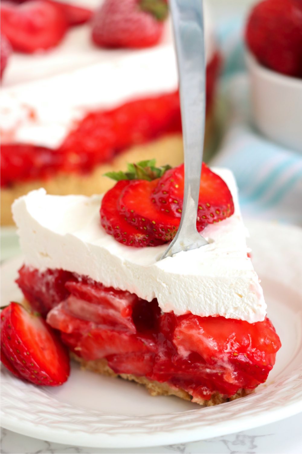 fork digging into a piece of strawberry pie